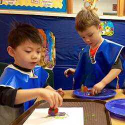 Boys painting with fruit and vegetable pieces